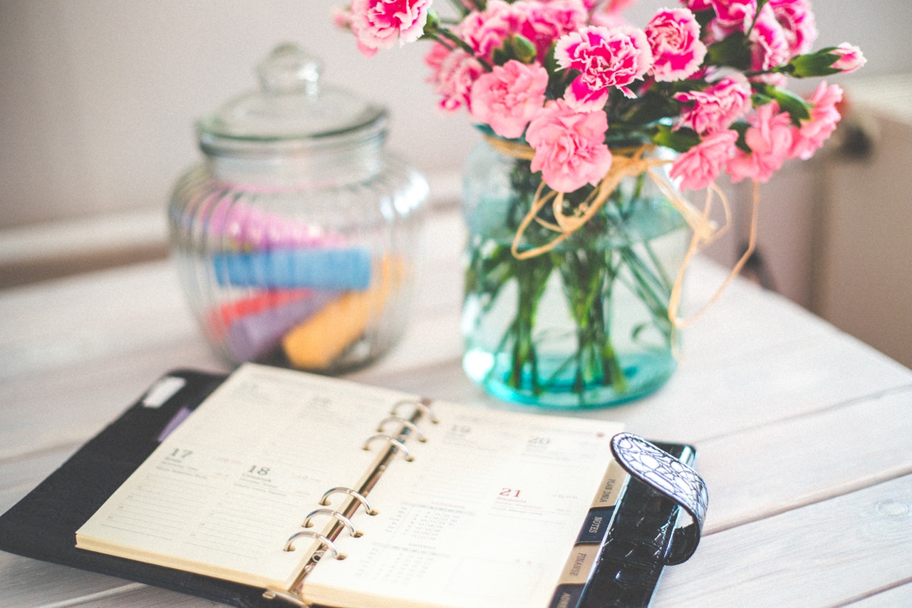Busy Schedule filofax with vase of flowers on desk